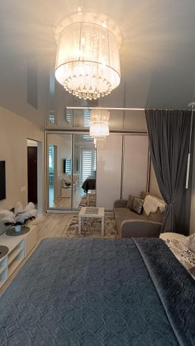 ドルスキニンカイにあるMEŠKUTĖS APARTAMENTAIの大きなベッドとシャンデリアのある寝室