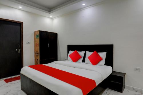 - une chambre avec un grand lit et des oreillers rouges dans l'établissement Flagship Ap Royal, à Indirapuram