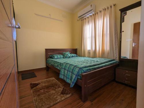 a small bedroom with a bed and a window at 2A Villa Innocent in Puducherry