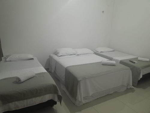 two beds in a room with white walls at Central Palace Hotel in Fortaleza