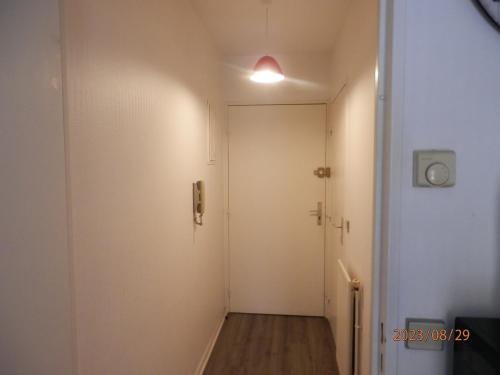 un couloir avec une porte blanche et un miroir dans l'établissement Arcachon centre 300m plage 50m gare SNCF, à Arcachon