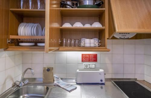 a kitchen with a sink and a counter top at GHT Balmes, Hotel-Aparthotel&SPLASH in Calella