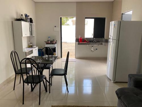 a kitchen and dining room with a table and a refrigerator at Flat Dona D - Prox da JK in Palmas