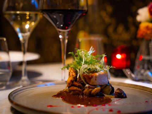 a plate of food on a table with wine glasses at Château de Candie in Chambéry