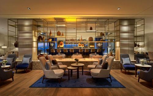 a lobby with a waiting room with chairs and tables at Grand Hotel Brioni Pula, A Radisson Collection Hotel in Pula