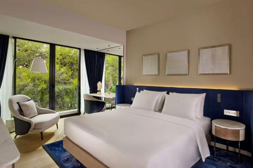 a bedroom with a large white bed and a chair at Grand Hotel Brioni Pula, A Radisson Collection Hotel in Pula