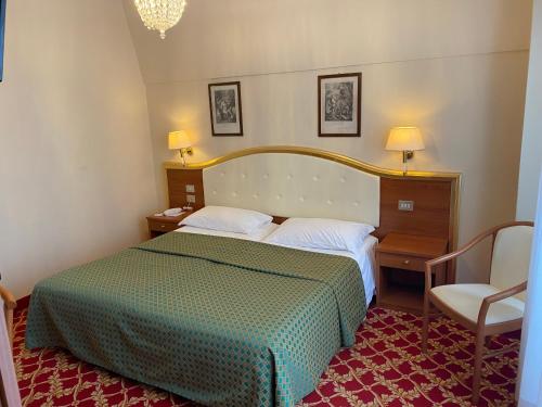 a hotel room with a bed and a chair at Hotel Milan Speranza Au Lac in Stresa