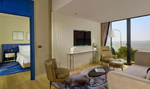 a hotel room with a bed and a living room at Grand Hotel Brioni Pula, A Radisson Collection Hotel in Pula