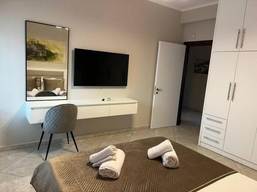 - une chambre avec une télévision et 2 serviettes sur un lit dans l'établissement Manga Apartments 3+1, à Gjirokastër