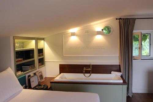 a bathroom with a bath tub and a bed at Giardini Penelope Resort e Spa in Ciampino
