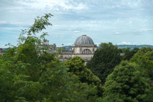 a building with a domed roof behind some trees at Park Plaza Cardiff in Cardiff