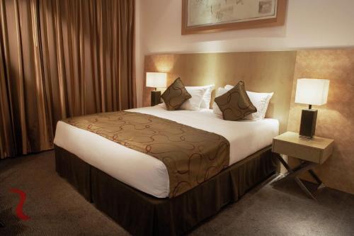 a hotel room with a large bed with white sheets and pillows at Park Plaza Cardiff in Cardiff