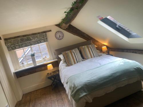 a bedroom with a bed and a window and a clock at Becs in Leominster