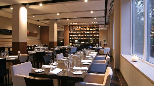 a dining room with a long table and chairs at Park Plaza Cardiff in Cardiff