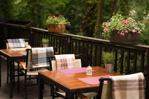 a wooden table and chairs on a deck with potted plants at Park Plaza Cardiff in Cardiff