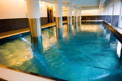 a swimming pool with blue water in a building at Park Plaza Cardiff in Cardiff