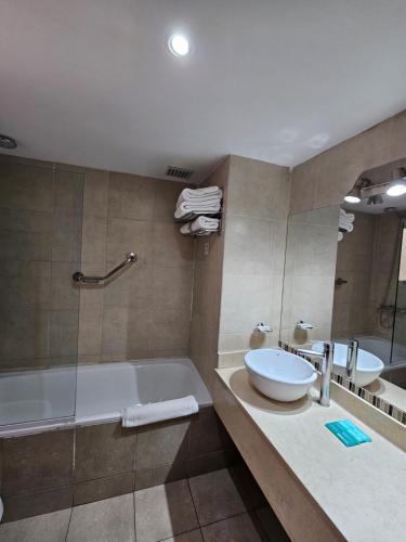a bathroom with a tub and a sink at DAKAR HOTEL in Mendoza