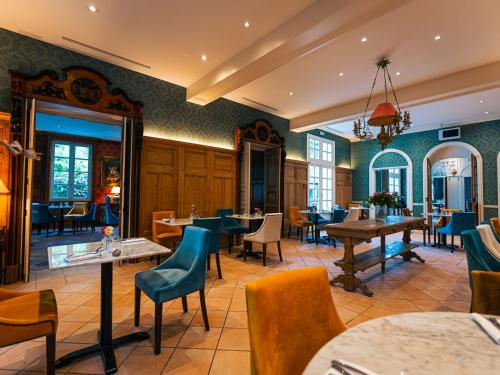 a restaurant with tables and chairs in a room at Château de Candie in Chambéry