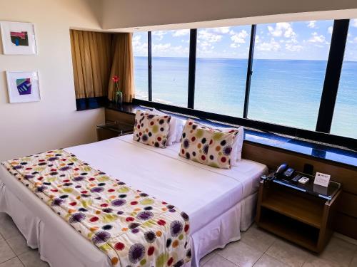 a bedroom with a bed with a view of the ocean at Hotel Euro Suíte Recife Boa Viagem By Nacional Inn in Recife