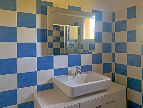 a bathroom with a sink and a mirror at Résidence Maora Village in Bonifacio