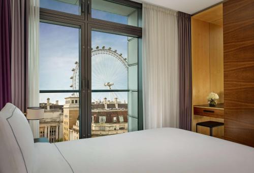 a bedroom with a large window with a view of the london eye at Park Plaza County Hall London in London