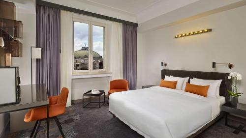 a bedroom with a large white bed and a window at Park Plaza Nuremberg in Nürnberg