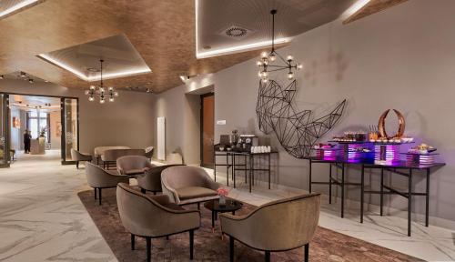 a salon with chairs and a bar with purple lights at Park Plaza Nuremberg in Nürnberg