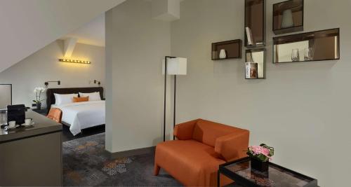 a hotel room with a bed and a chair at Park Plaza Nuremberg in Nürnberg