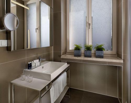 a bathroom with a sink and two potted plants at Park Plaza Nuremberg in Nürnberg
