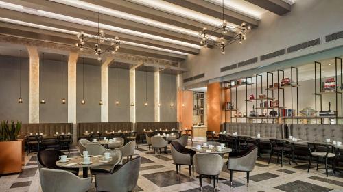a restaurant with tables and chairs in a room at Park Plaza Nuremberg in Nürnberg