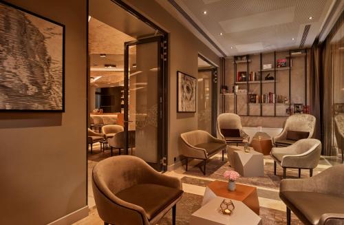 a waiting room with chairs and a table and a bar at Park Plaza Nuremberg in Nürnberg