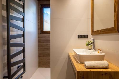 a bathroom with a sink and a mirror at Chalet La Tribu du Danay, neuf, 12 personnes in Saint-Jean-de-Sixt