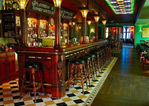 a bar with a row of stools in a pub at Afrika Hotel Frýdek-Místek in Frýdek-Místek