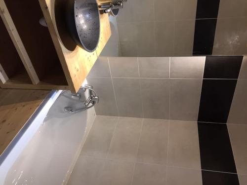 - une salle de bains revêtue de carrelage noir et blanc dans l'établissement Paradiski calme et ensoleillé plan peisey, à Peisey-Nancroix