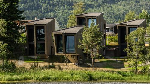 uma fila de casas modulares ao lado de um lago em Elva Hotel em Skulestadmo