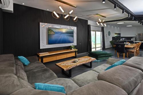 a living room with a couch and a table at וילה Vision - וילה מדהימה בקצה היישוב עם בריכה ונוף עוצר נשימה in H̱azon