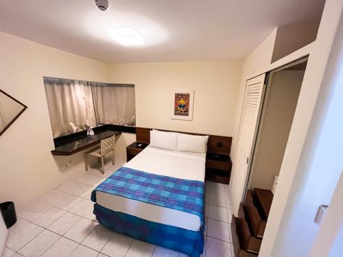 - une petite chambre avec un lit et un bureau dans l'établissement Hotel Euro Suíte Recife Boa Viagem, à Récife