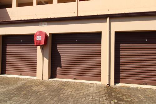 tres puertas de garaje en el lateral de un edificio en Sea Breeze West 5, en Margate