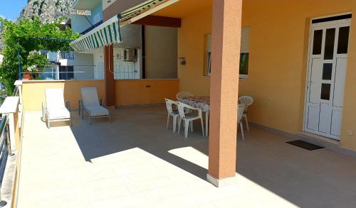 a patio with a table and chairs on a house at Seaview Apartment Tony with Grand Terrace in Omiš