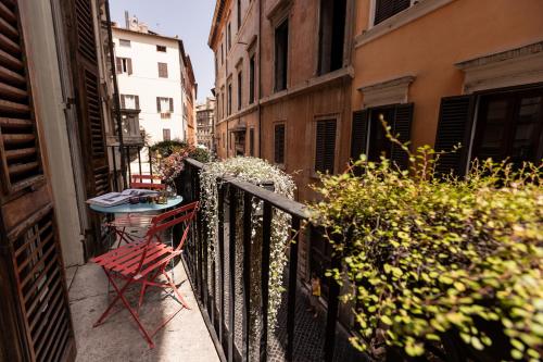 einen Balkon mit einem Tisch und einem Stuhl auf dem Balkon in der Unterkunft Passepartout in Rom