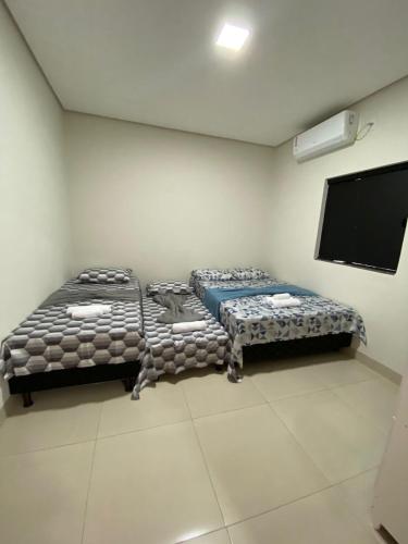 a room with two beds and a flat screen tv at Flat 03 - Prox da JK - Delior 2 in Palmas