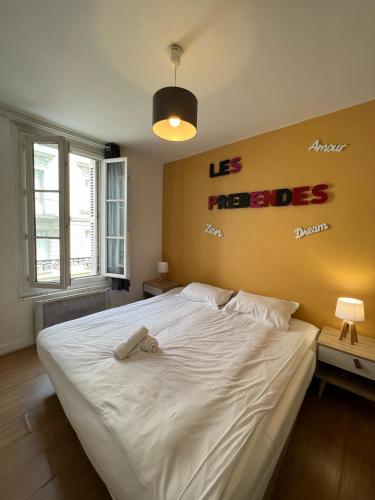 - une chambre dotée d'un grand lit blanc avec les mots qu'il a rappelés dans l'établissement F2 face au Jardin des prébendes de Tours, à Tours