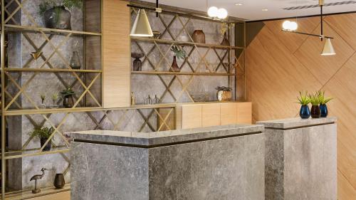 a lobby with a concrete counter with potted plants at Park Plaza Utrecht in Utrecht