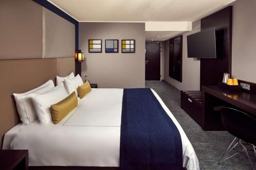 a hotel room with a large bed and a desk at Park Plaza Utrecht in Utrecht