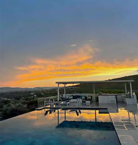 une maison avec une piscine au coucher du soleil en arrière-plan dans l'établissement Luxury house, St tropez 20mns! Stunning view, serene & private, à Grimaud
