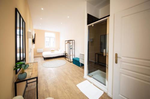 ein Wohnzimmer mit einer Tür, die zu einem Schlafzimmer führt in der Unterkunft NG SuiteHome - Lille I Roubaix Barbieux I Croix - Netflix - Wifi in Roubaix