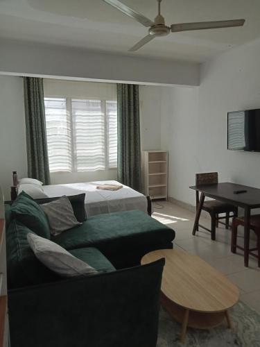 a living room with a couch and a bed and a table at Studio Apartment.Mombasa, Kenya in Mombasa
