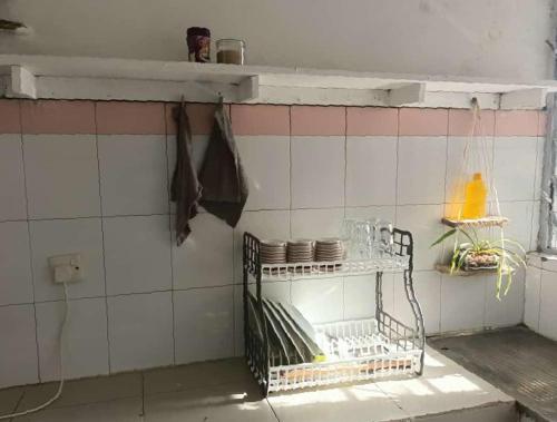 a kitchen with a shelf with dishes on a tiled wall at Studio Apartment.Mombasa, Kenya in Mombasa