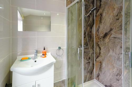 a bathroom with a sink and a shower at Headingley 2 Bedroom cottage flat Near Universities shops& Park in Leeds