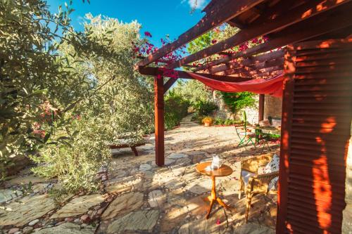 a patio with a red canopy and a table and chairs at Villa Narlidere in Mesudiye